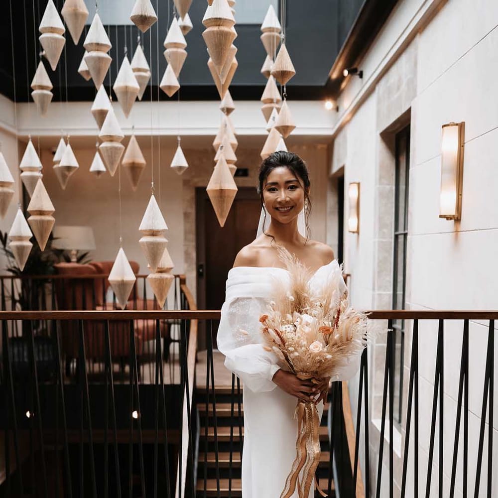 Bride in long draping wedding dress with detailed sparkly sleeves 