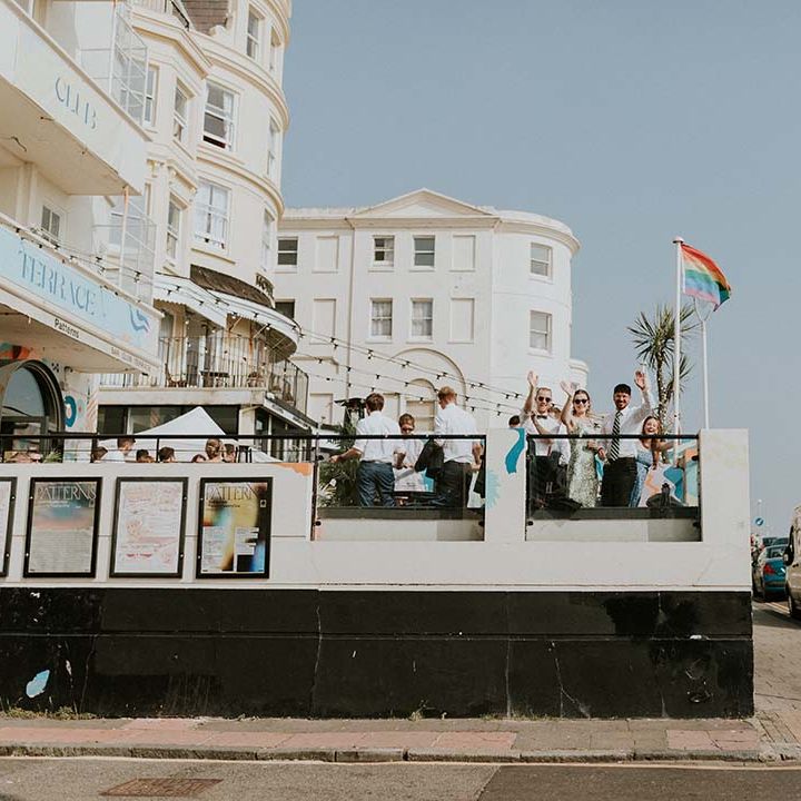 Wedding guests wave from balcony 