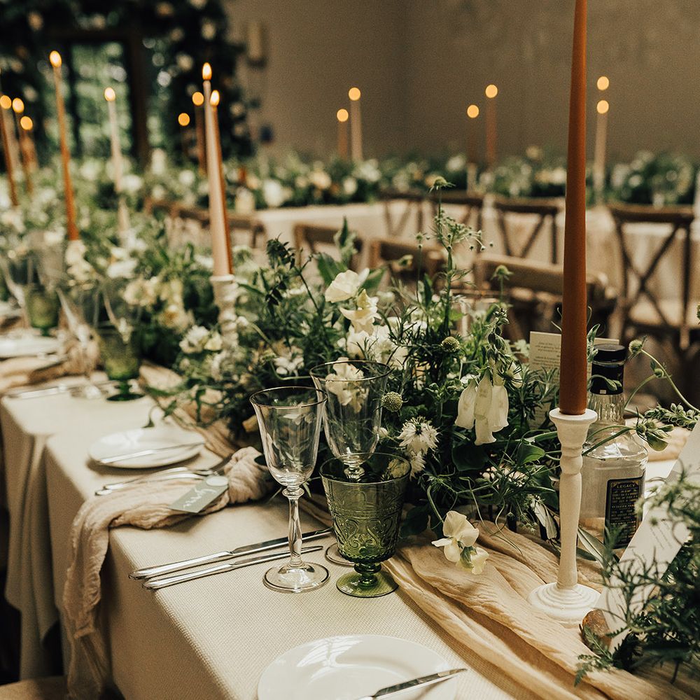 Beautifully styled wedding reception at Foxhill Manor by The Stars Inside with foliage flowers, linen table runner, white candlesticks and taper candles 