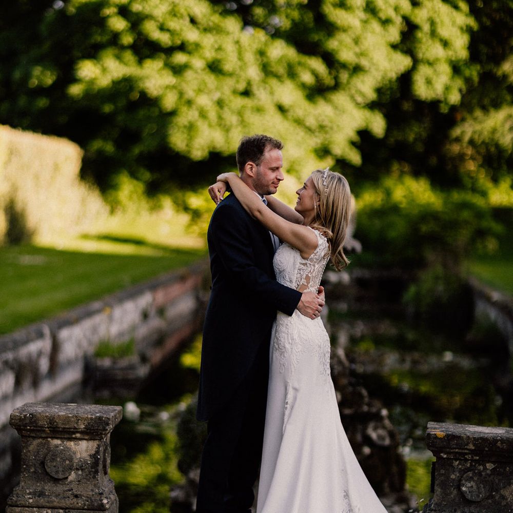 Cute couple portrait of bride and groom on their wedding day at Goldney Hall with bride in lace wedding dress and groom wearing traditional morning suit 