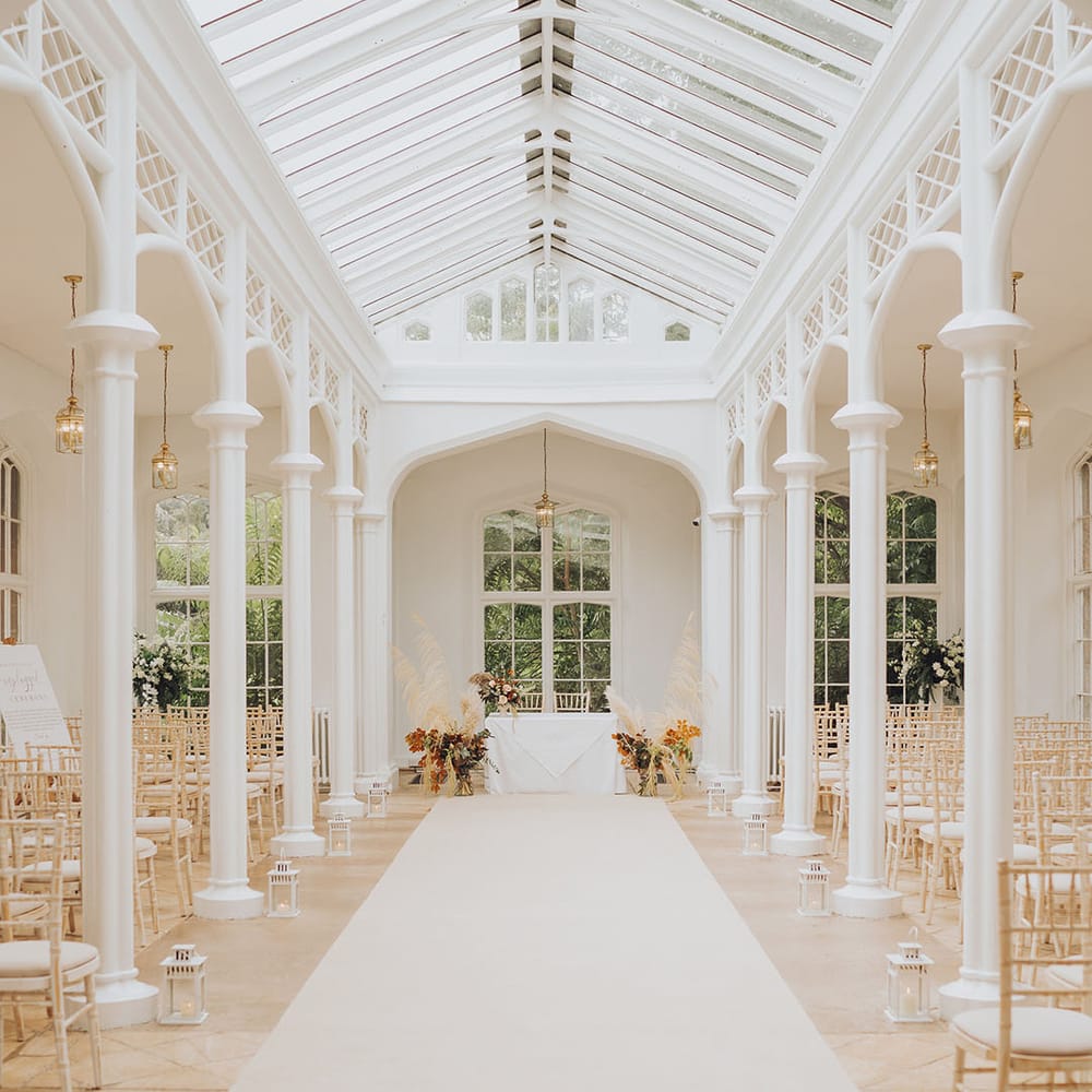 St Audries Park wedding venue complete with lanterns lining the aisle and pampas grass installations to the front of the aisle 