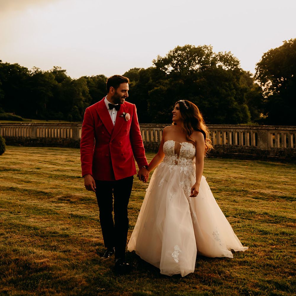 Golden hour couple portrait of the bride and groom at the end of their day with groom in velvet suit jacket and bride in tulle dress 