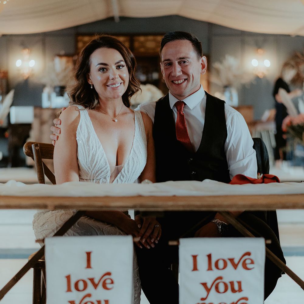 Custom made white and burnt orange wedding banners hanging from the top table for the bride and groom 
