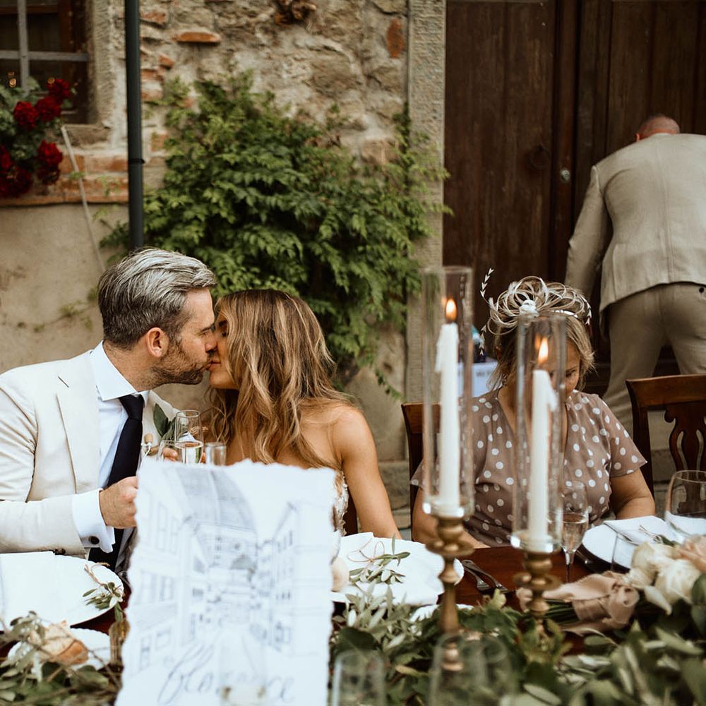 Bride and groom share a kiss during the wedding breakfast at destination wedding