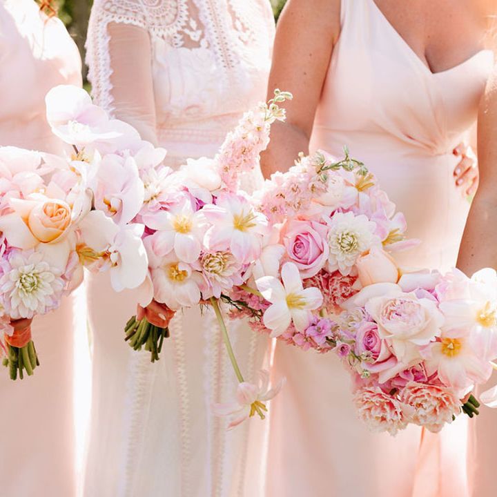 Bride and bridesmaids holding baby pink wedding bouquets with peonies, reflexed tulips, dahlias and more 