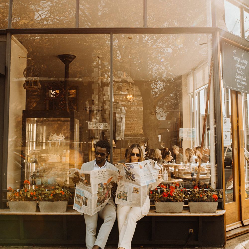 Bride and groom reading newspapers at city elopement 