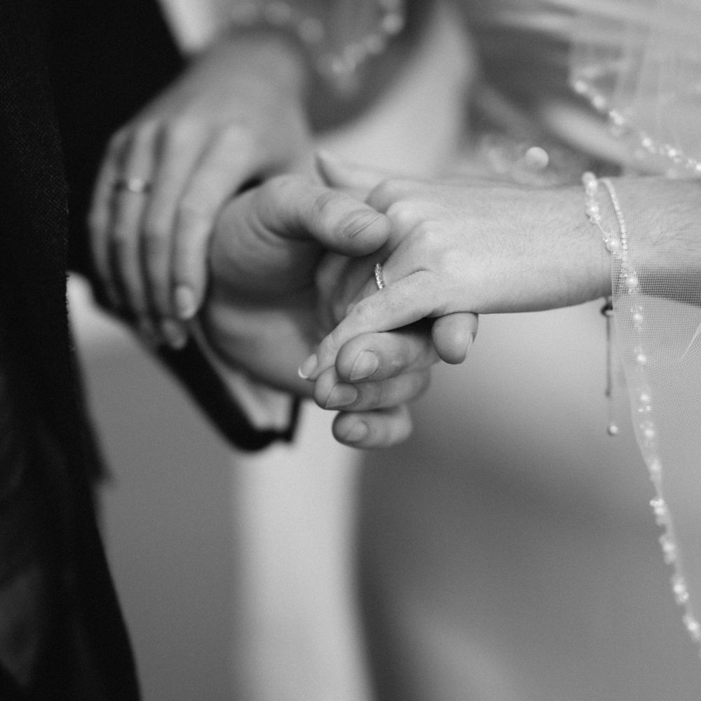 Bride & groom hold hands during wedding ceremony 