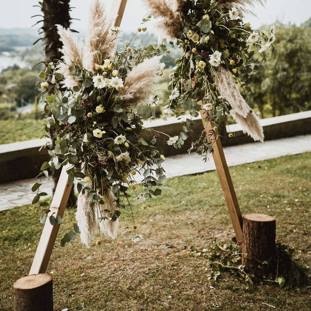Wooden framed altar with pampas grass, foliage and yellow Billy Buttons