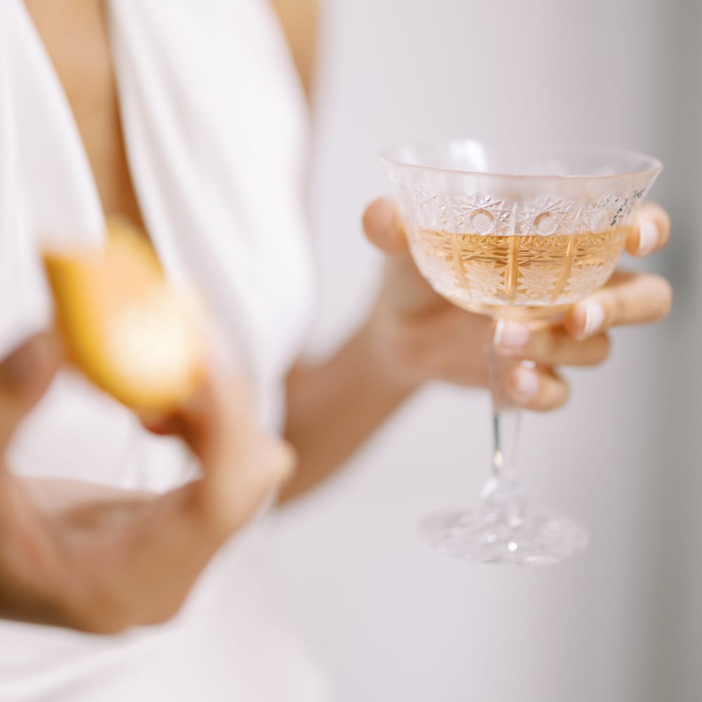 Bride holds champagne glass filled with champagne 