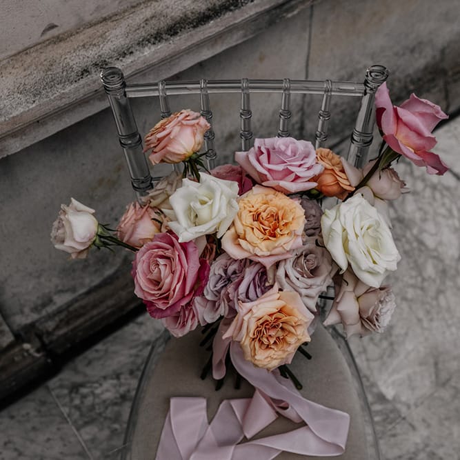 Blush pink, white and peach peeled back rose wedding bouquet tied with ribbon 