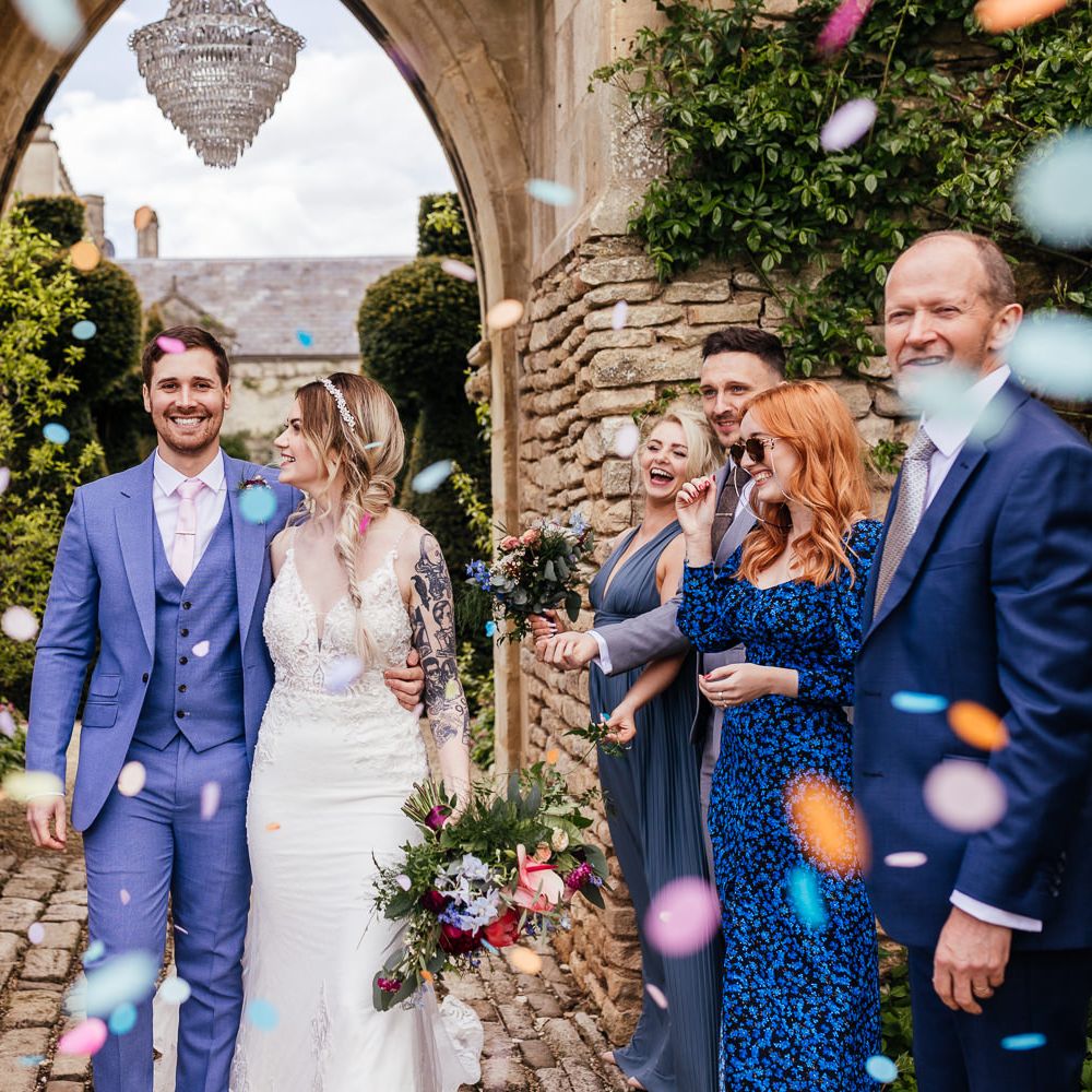 Bride & groom walk together through arch on their wedding day