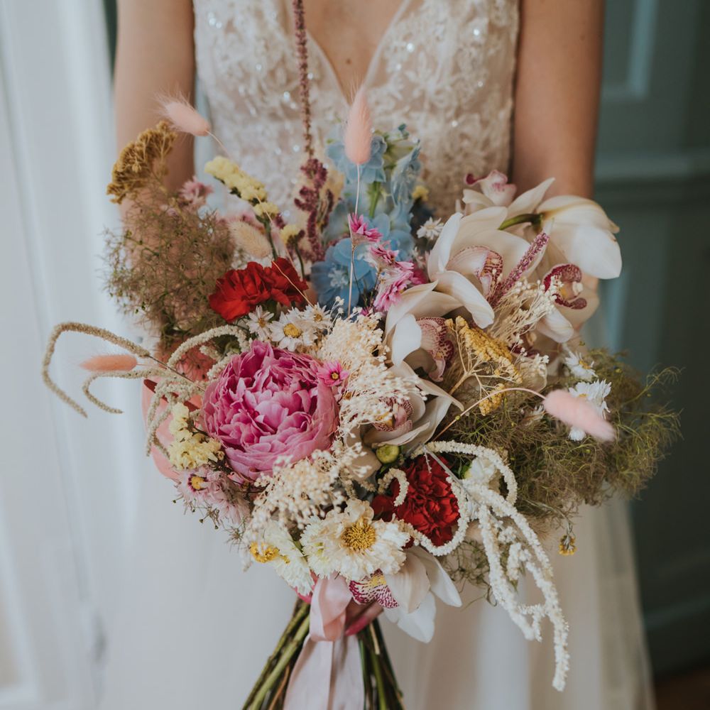 Colourful mixed flower wedding bouquet with peonies, carnations and orchids 