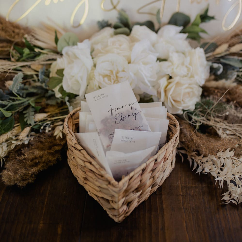 Personalised vellum confetti envelopes in a wicker basket 