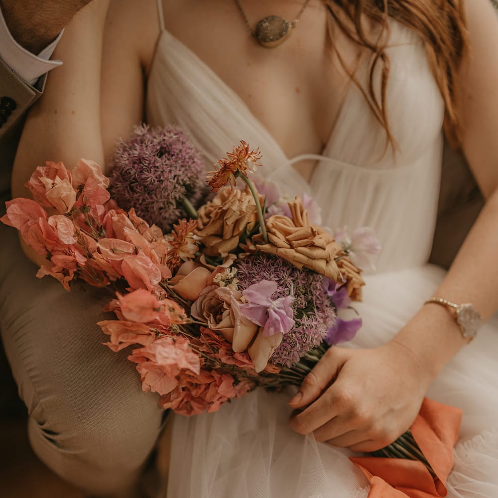 Pastel orange, pink and lilac wedding bouquet with alliums and roses 