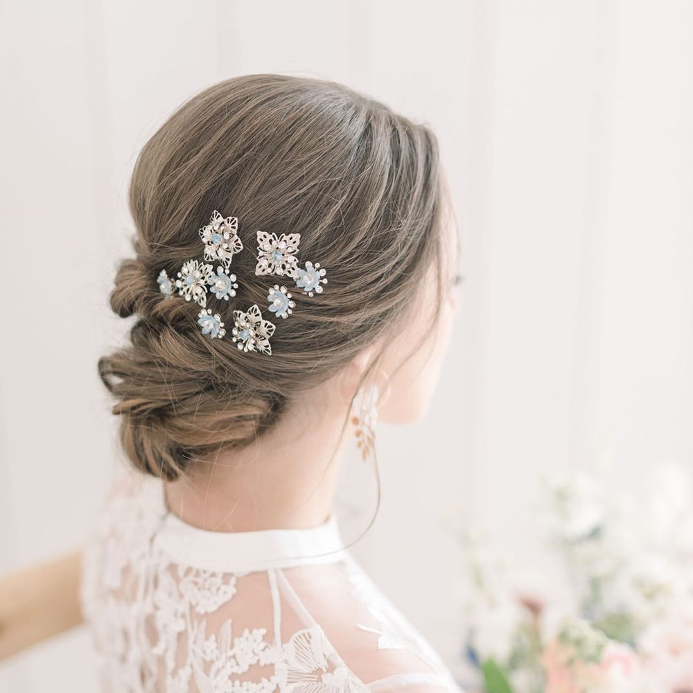 Bride with a pinned up do decorated with delicate blue hair pins 