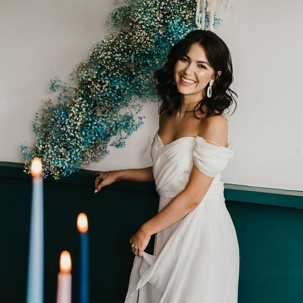 Beautiful bride with natural makeup and shoulder length wavy hair in a cold shoulder Medusa London wedding dress