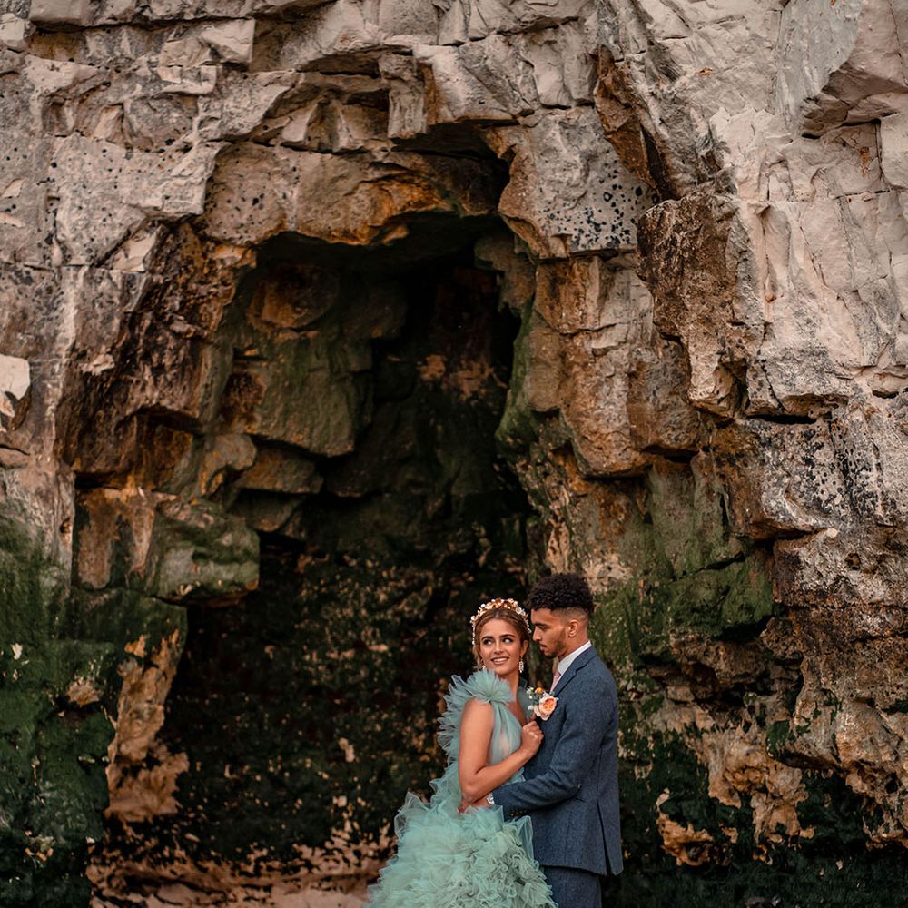Botany Bay coastal wedding inspiration with bride in a mint green Millia of London frilly wedding dress and groom a blue wool suit 