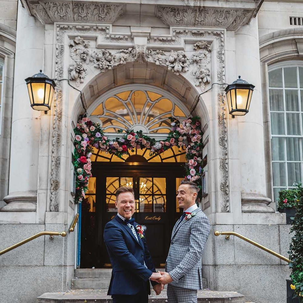 Grooms stand in front of Chelsea Old Town Hall