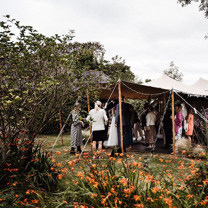 Wedding guests gather under canopy for outdoor wedding at Treseren wedding venue