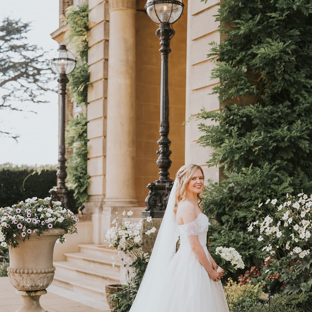 Bride in ballgown wedding dress with off the shoulder wedding dress with white flower bouquet 