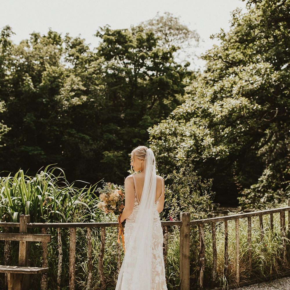 Bride wearing a floor length veil and Made With Love lace wedding dress 
