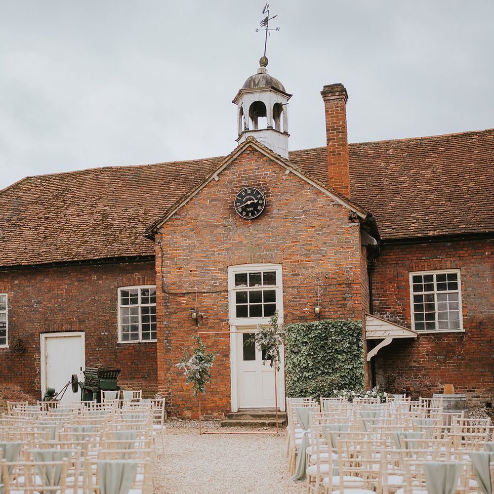 Outdoor wedding ceremony at Stanlake Park wedding venue with a green and white colour palette
