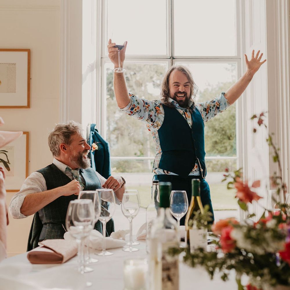 Groom celebrates during wedding speeches for intimate reception 
