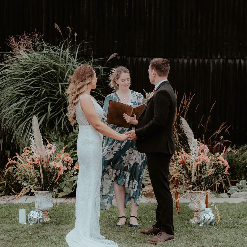 Humanist wedding celebrant stand with the bride and groom at their outdoor wedding ceremony at Rhyse Farm 