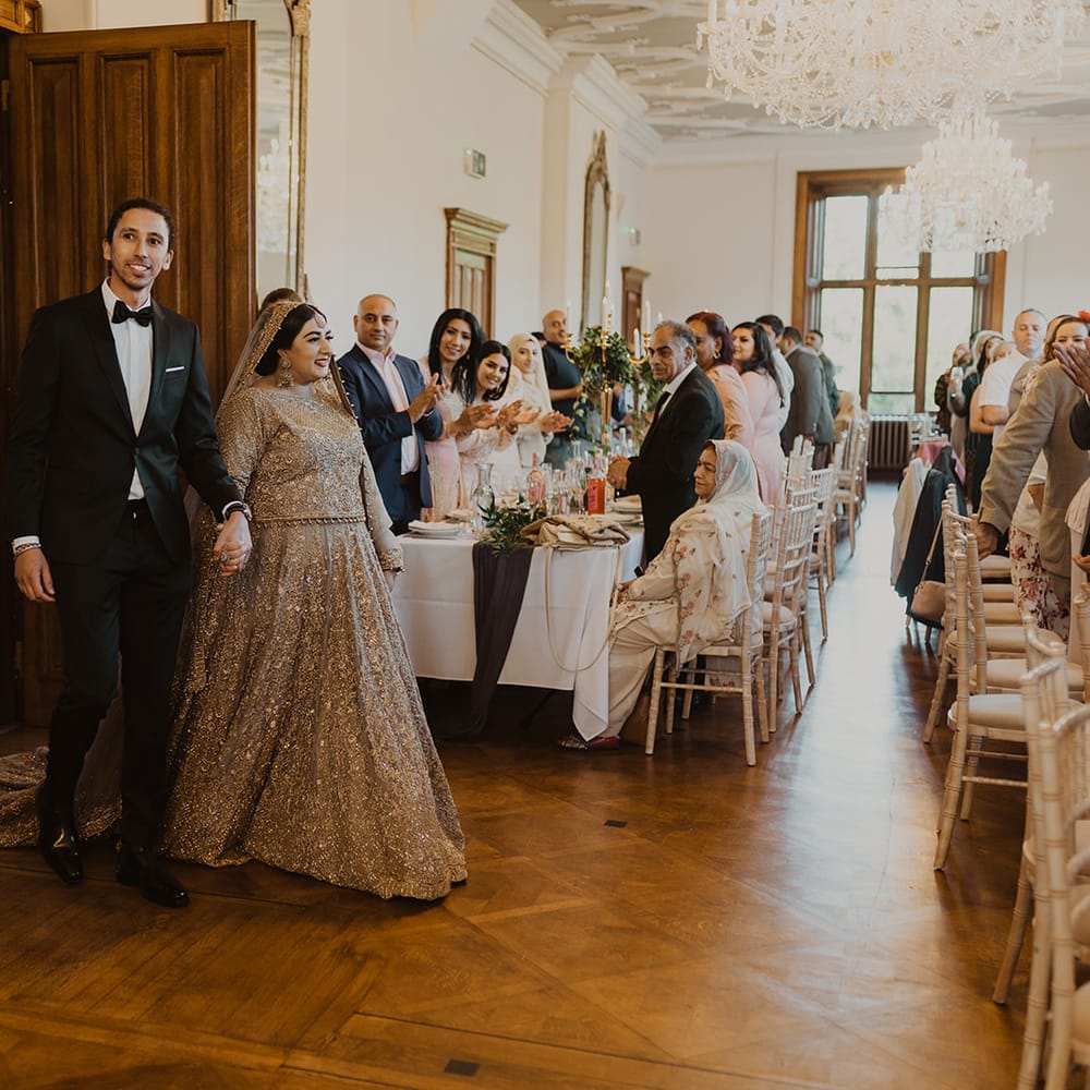 Bride and groom entering their multicultural wedding reception 
