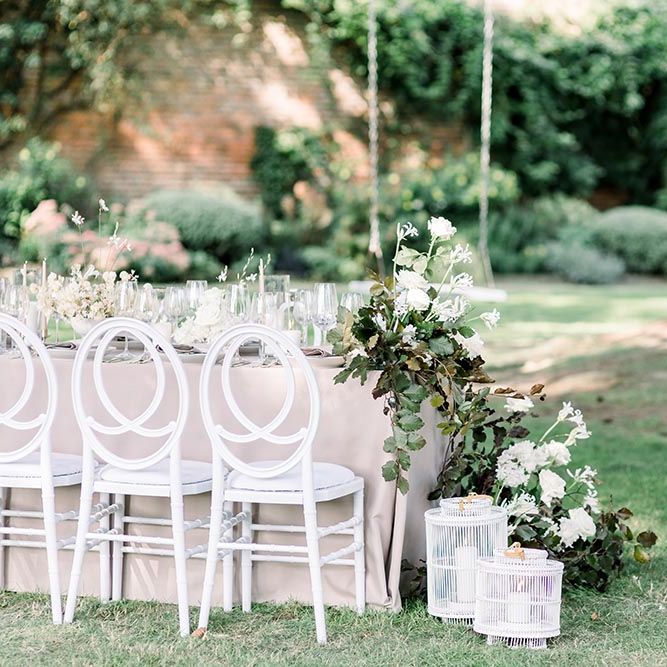 Wedding table floral arrangements with white flowers and foliage 
