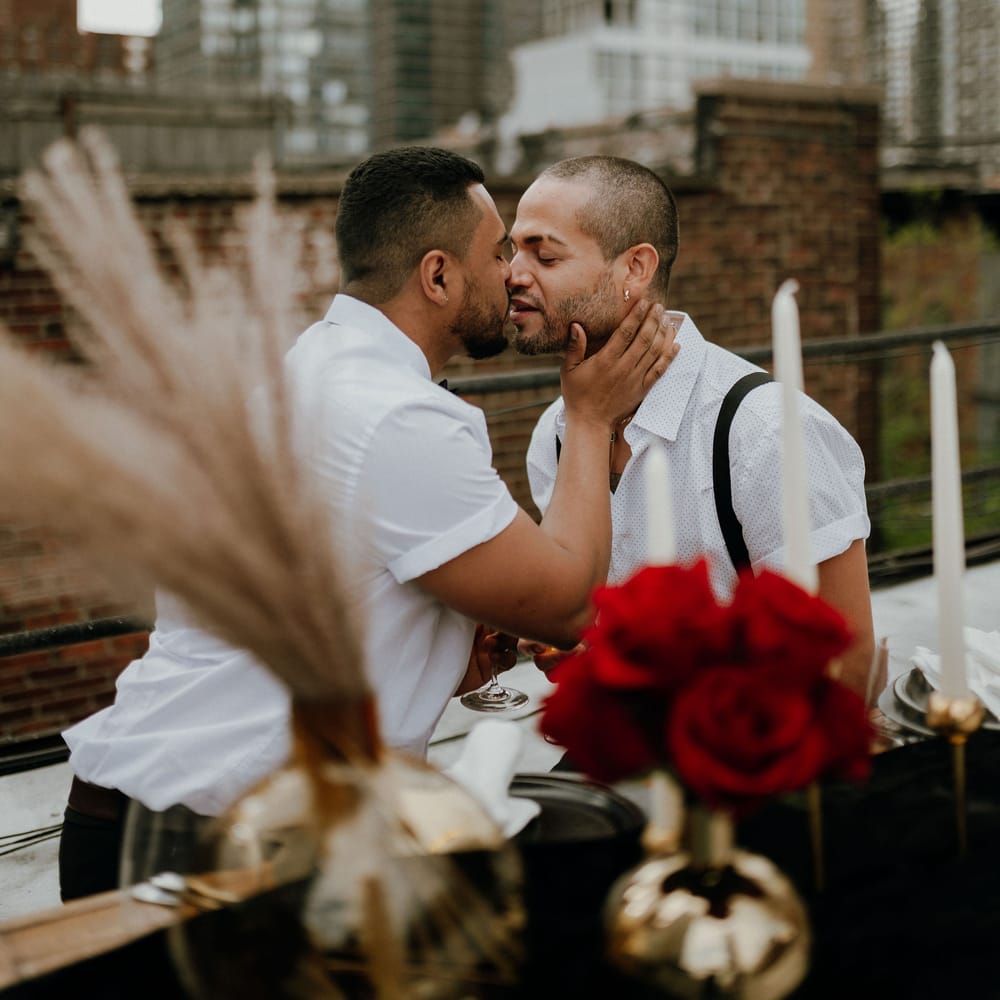 Grooms share a kiss at intimate rooftop elopement