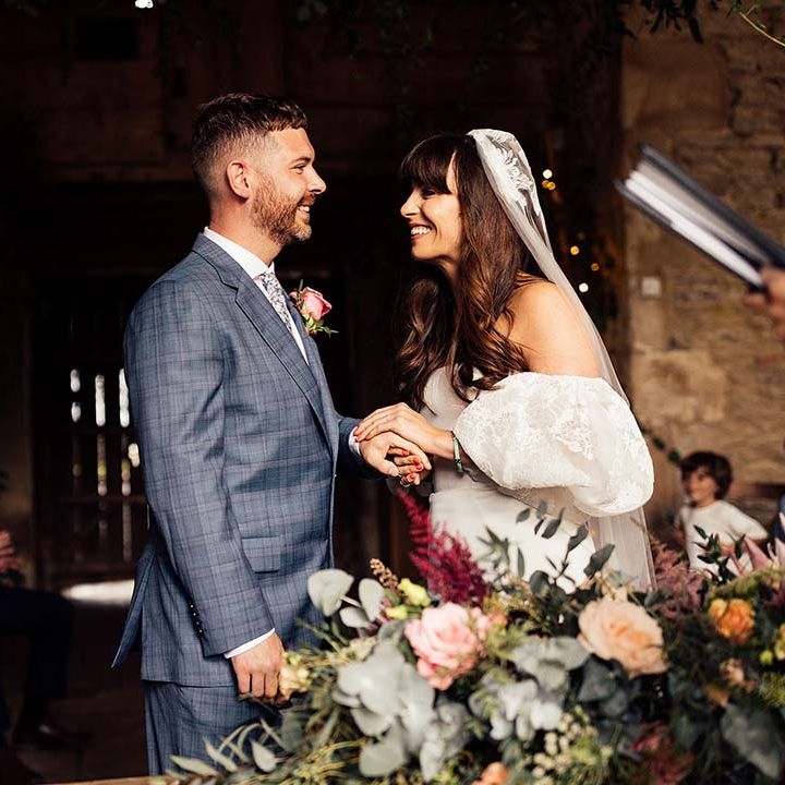 Bride & groom look lovingly at one another on their wedding day during ceremony