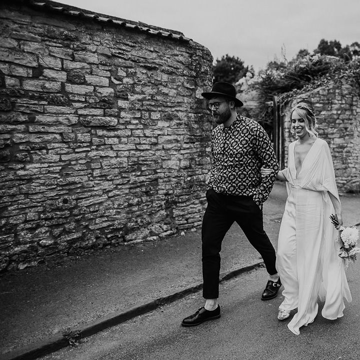 Bride & groom walk together through the streets on their wedding day