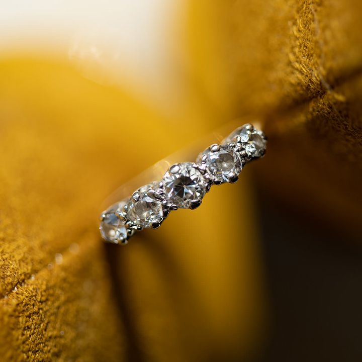 Diamond wedding ring against yellow background
