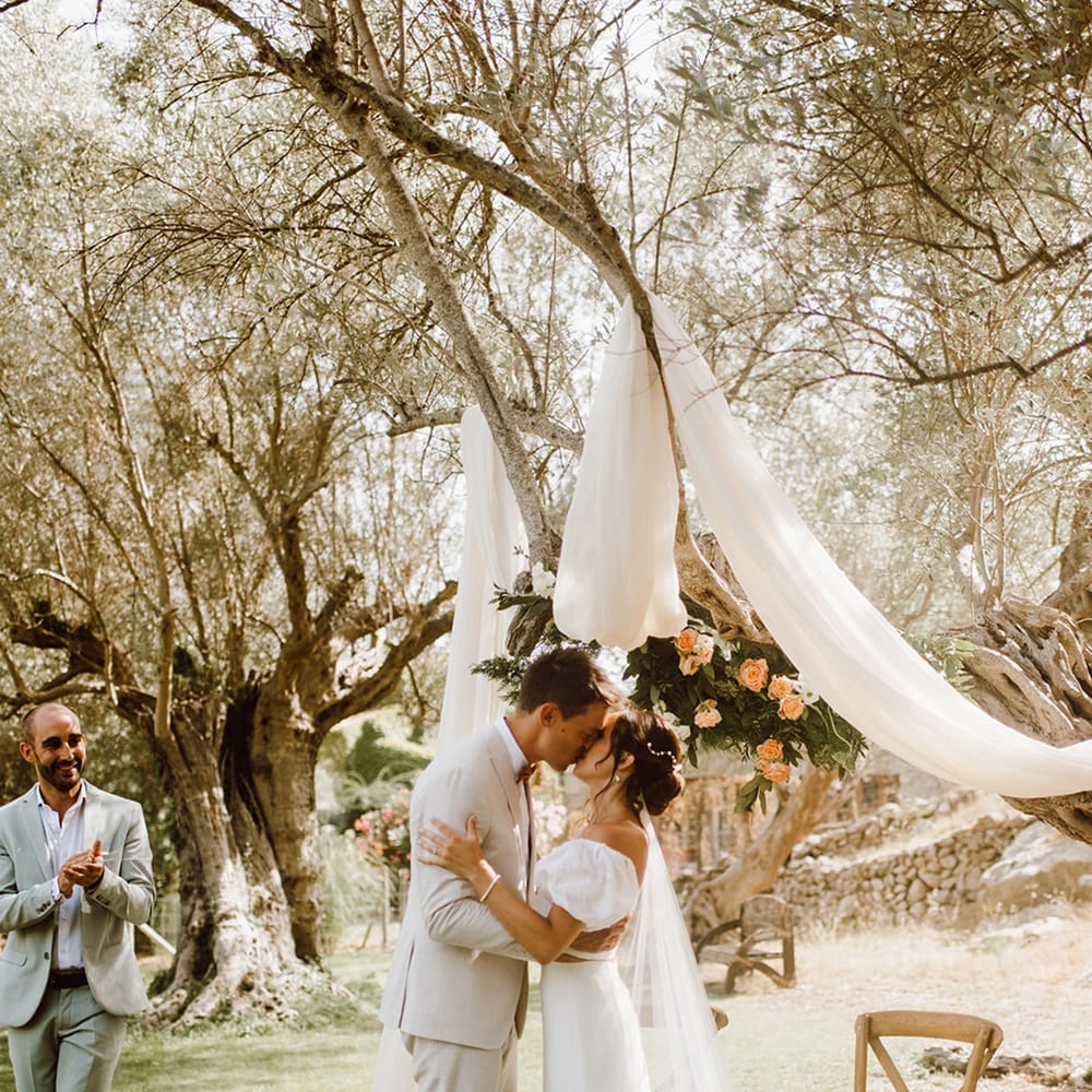 bride in puff sleeve dress shares first kiss with groom 