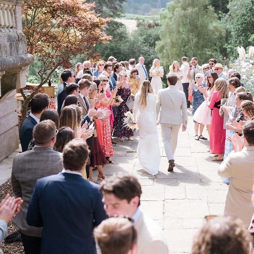 Bride and groom walk through their wedding guests at their outdoor wedding at Georgian home in Bath
