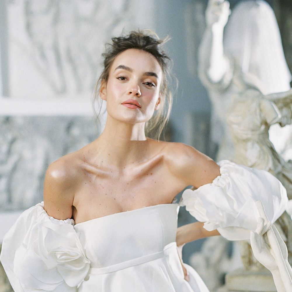 Bride in fitted extreme puff sleeve wedding dress and messy updo
