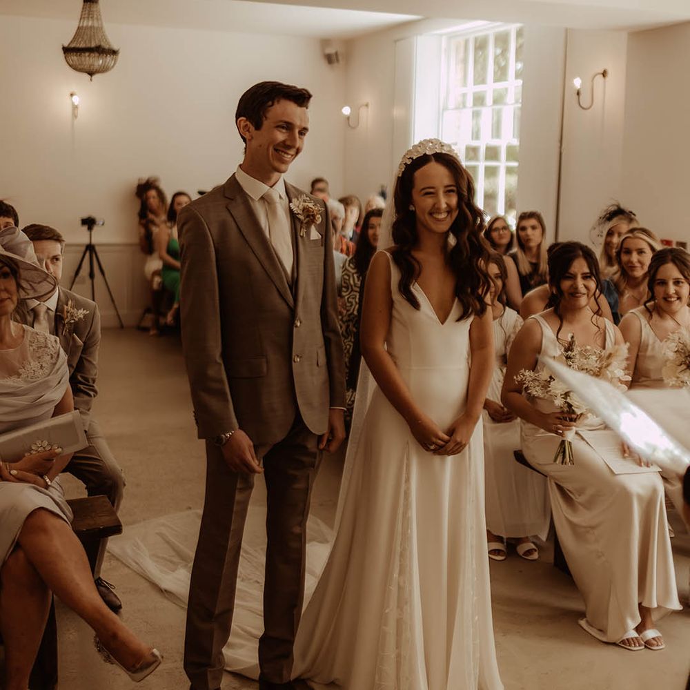Bride and groom smile during their wedding ceremony for boho luxe wedding 