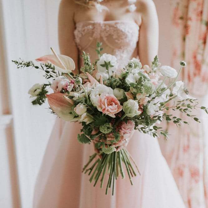 Pink and white spring flower wedding bouquet with anthuriums, roses, anemones and peony tulips