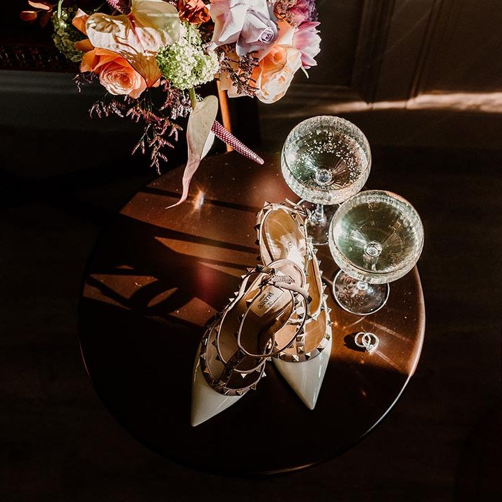 Pointed studded Valentino wedding heels with glasses of alcohol 
