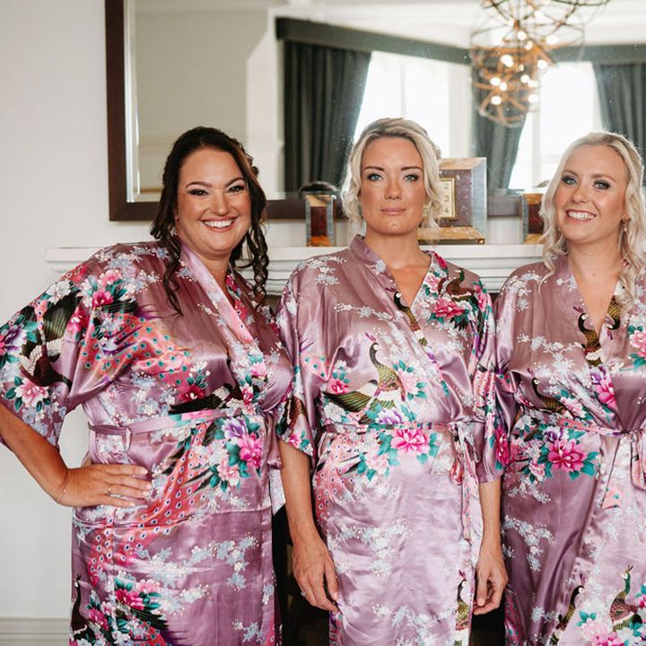 Bridal party getting ready for the wedding in purple patterned satin robes 