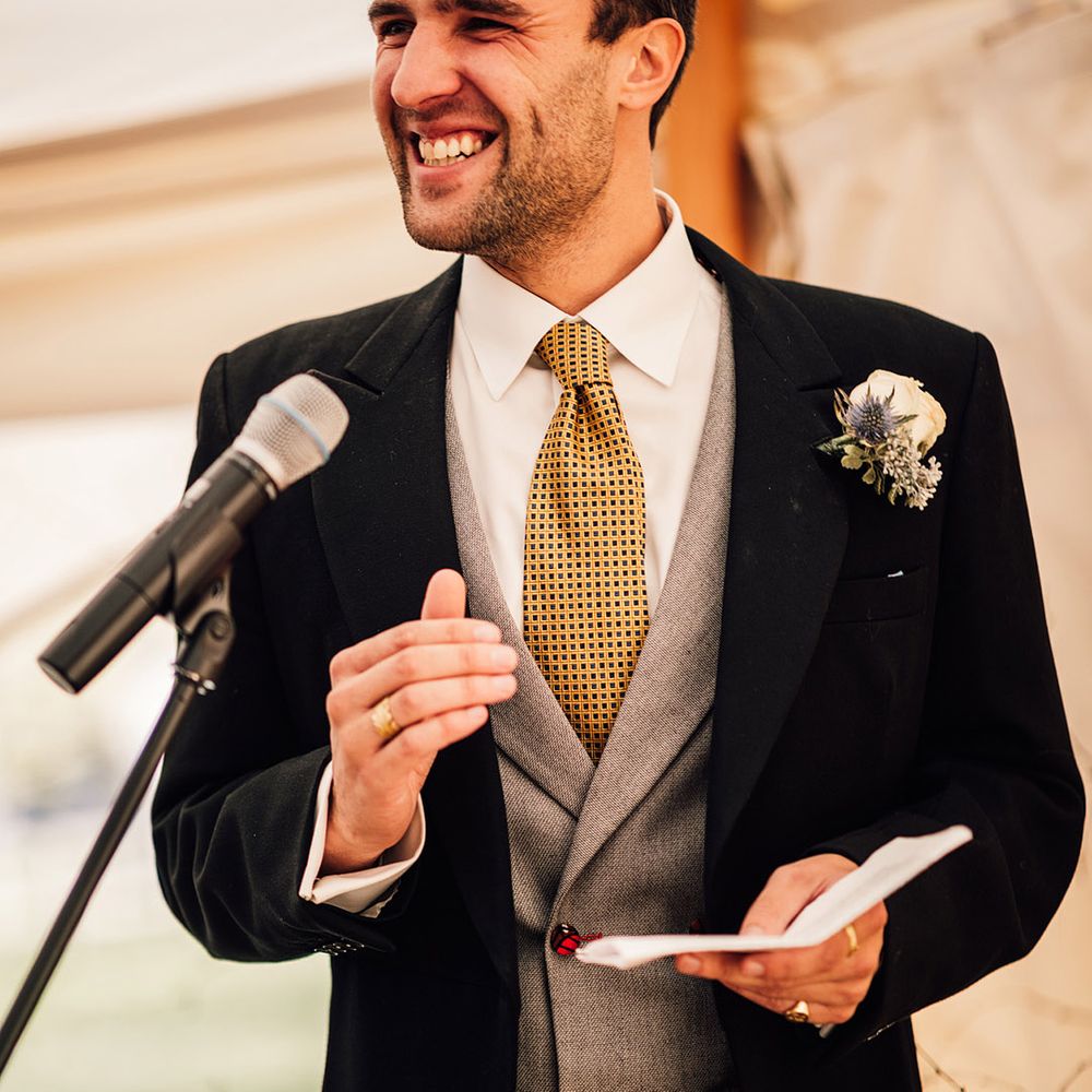 Groom in black morning suit with yellow tie and grey waistcoat 