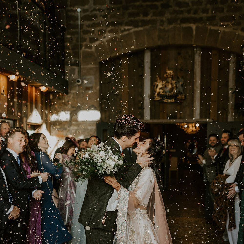 The bride and groom exit their interfaith wedding ceremony to confetti 