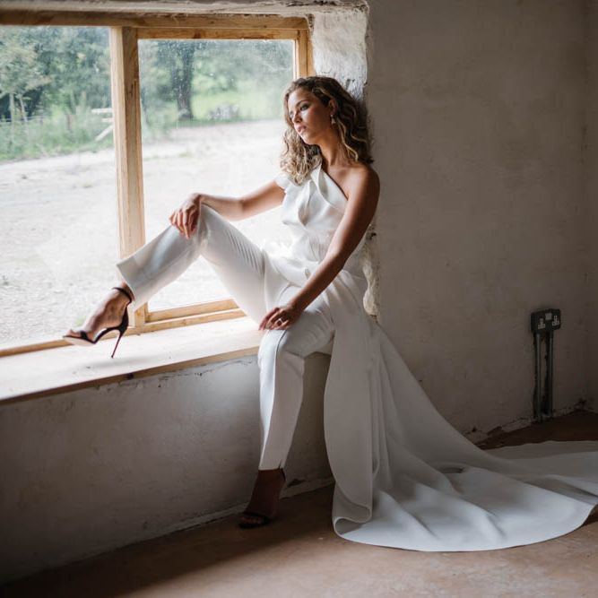 bride in white jumpsuit with wedding train 