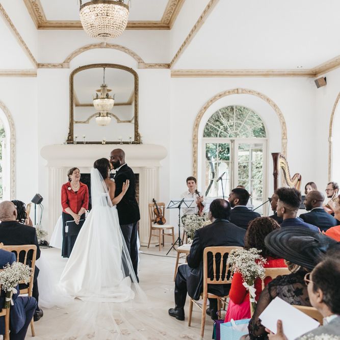 Bride and groom kissing at the altar of their Northbrook Park wedding ceremony 