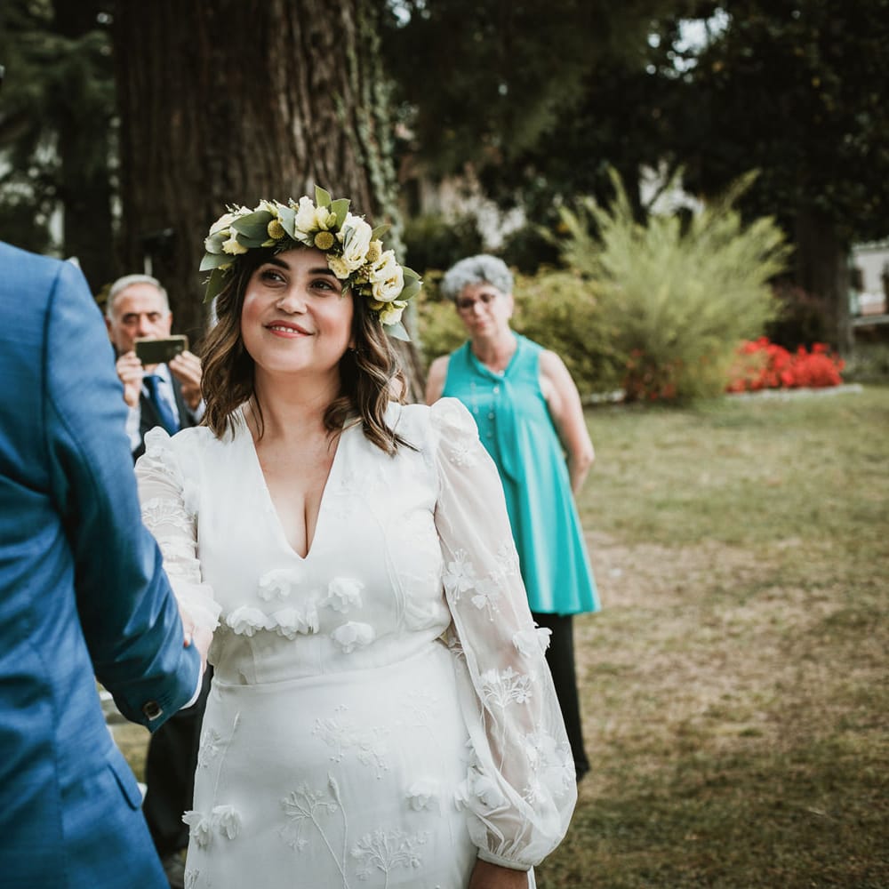 Bohemian bride in a white wedding dress with flowers and long sleeves.