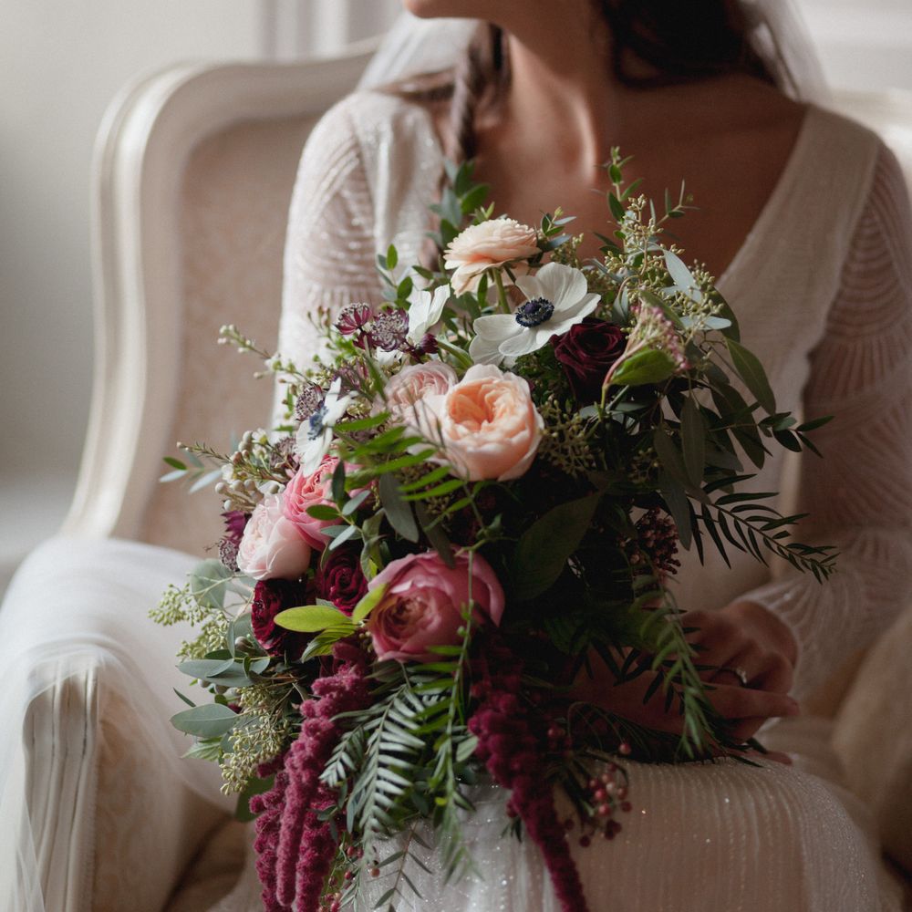 Bride to be on her wedding day holding berry, Peach and pink bridal bouquet 
