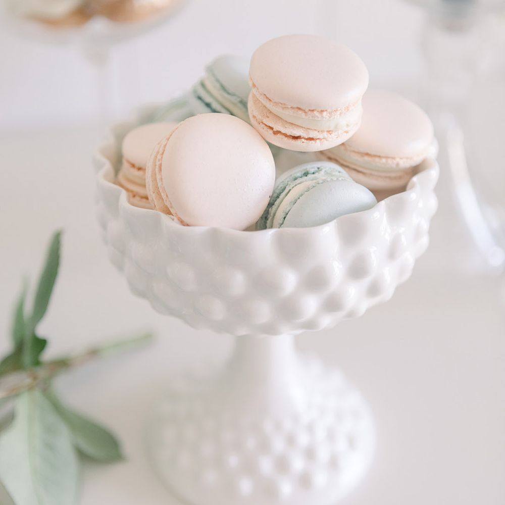 Pastel pink and blue macaroons in a milk glass vase 
