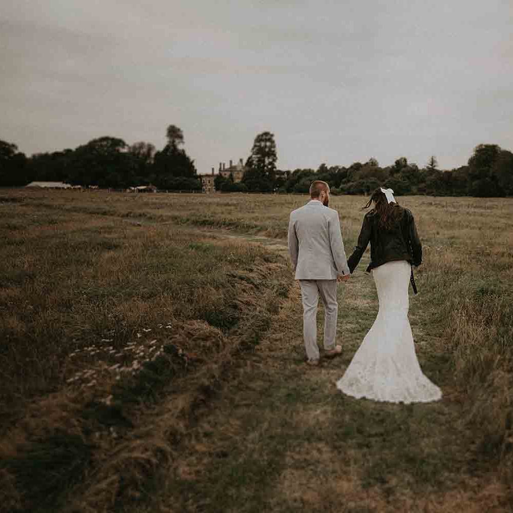 Bride in leather jacket cover up over her lace wedding dress