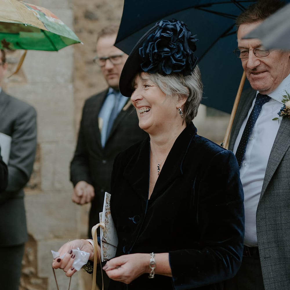 Wedding guest in navy outfit and hat with large flower detail